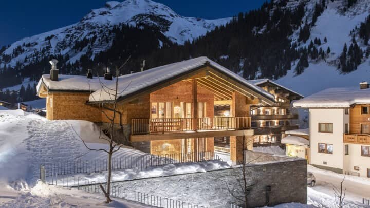 Ski chalet exterior with wrap-around balcony and direct mountain views