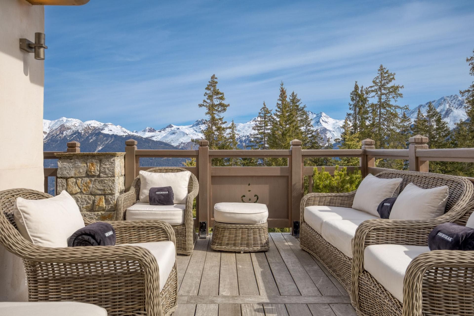 Private deck with wicker seating and panoramic Alpine mountain views