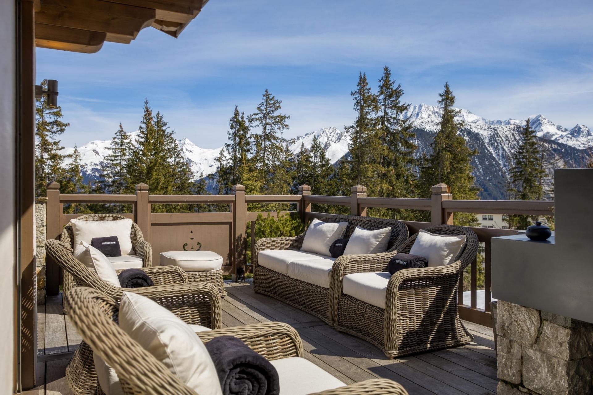 Private deck with wicker lounge seating and mountain range views
