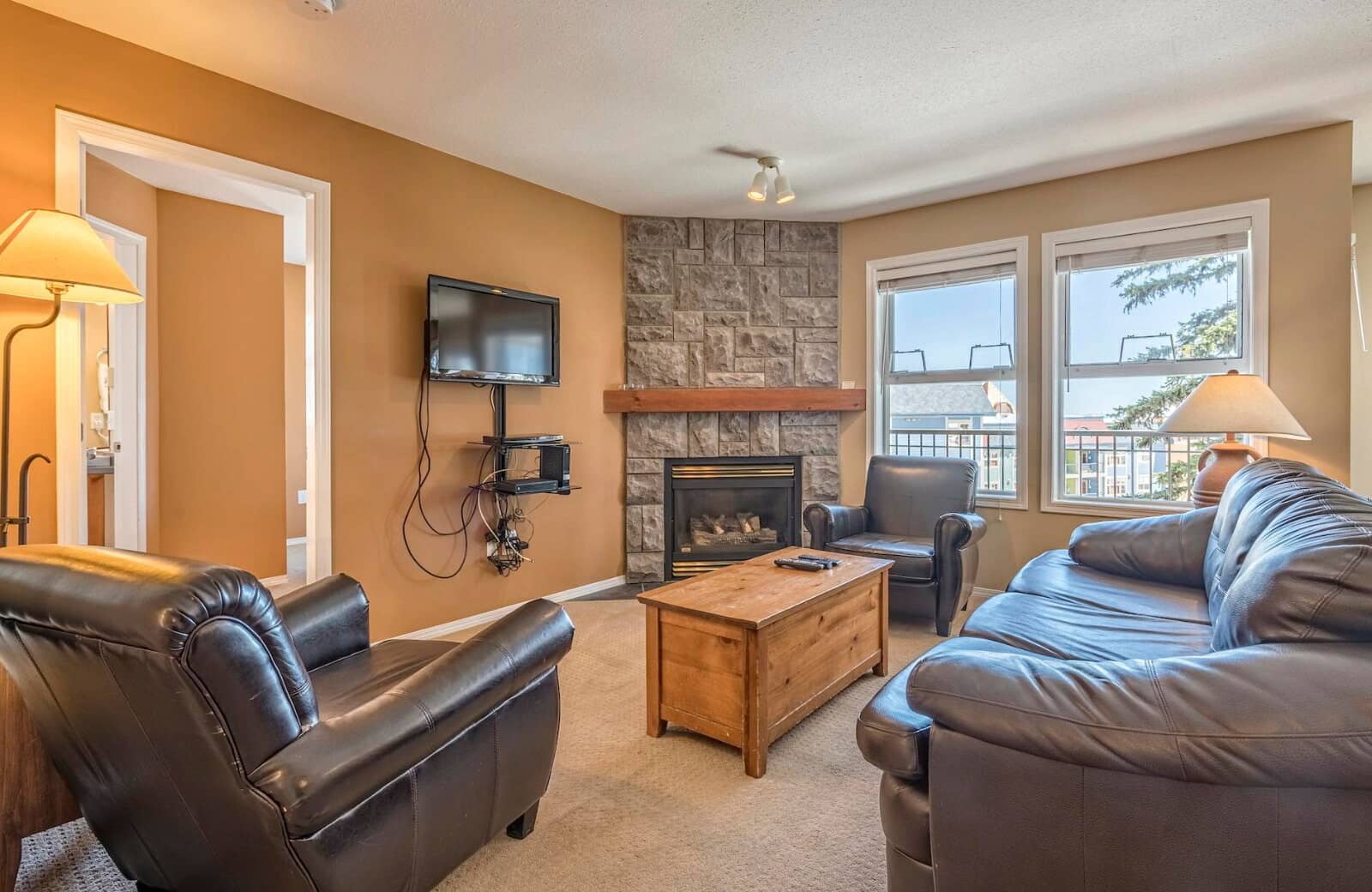 Living area with stone gas fireplace and leather seating for 5