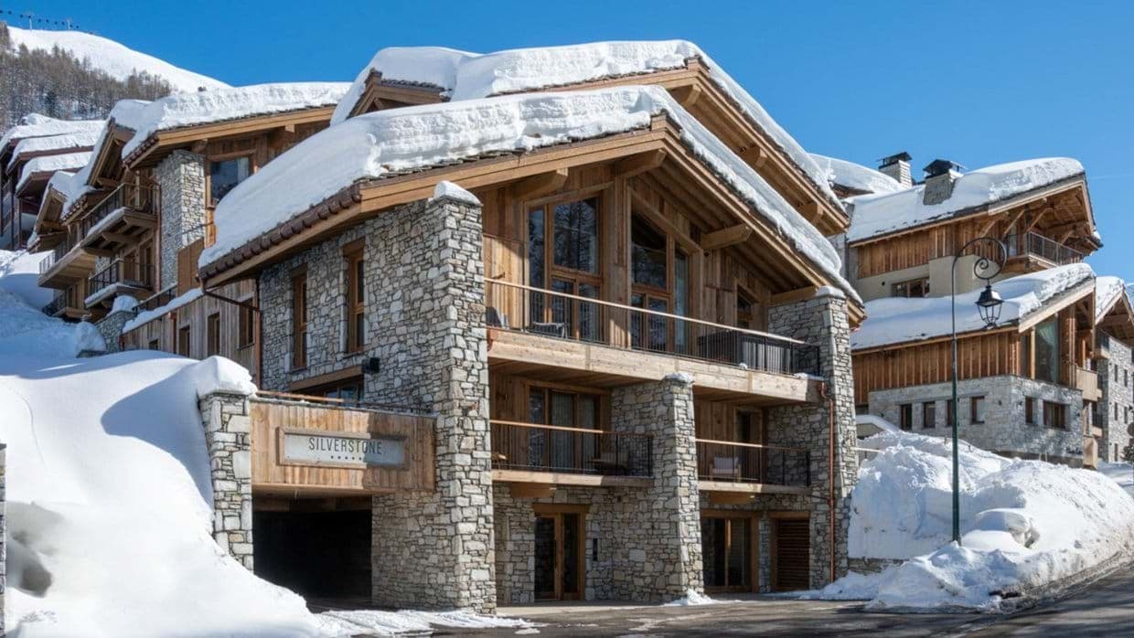 Ski-in/ski-out chalet exterior with private garage and heated stone balconies
