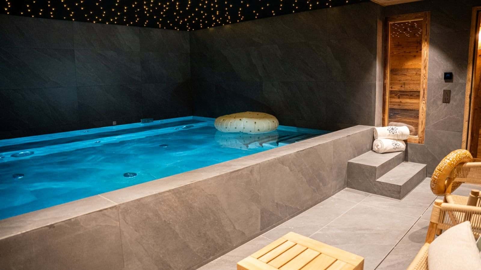Indoor swimming pool with integrated stone steps and starlight ceiling