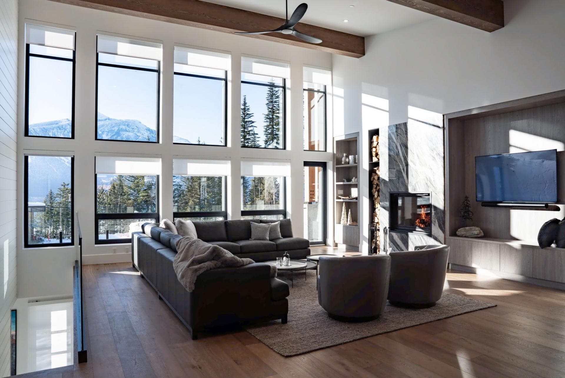Living area with floor-to-ceiling mountain views and wood-burning fireplace