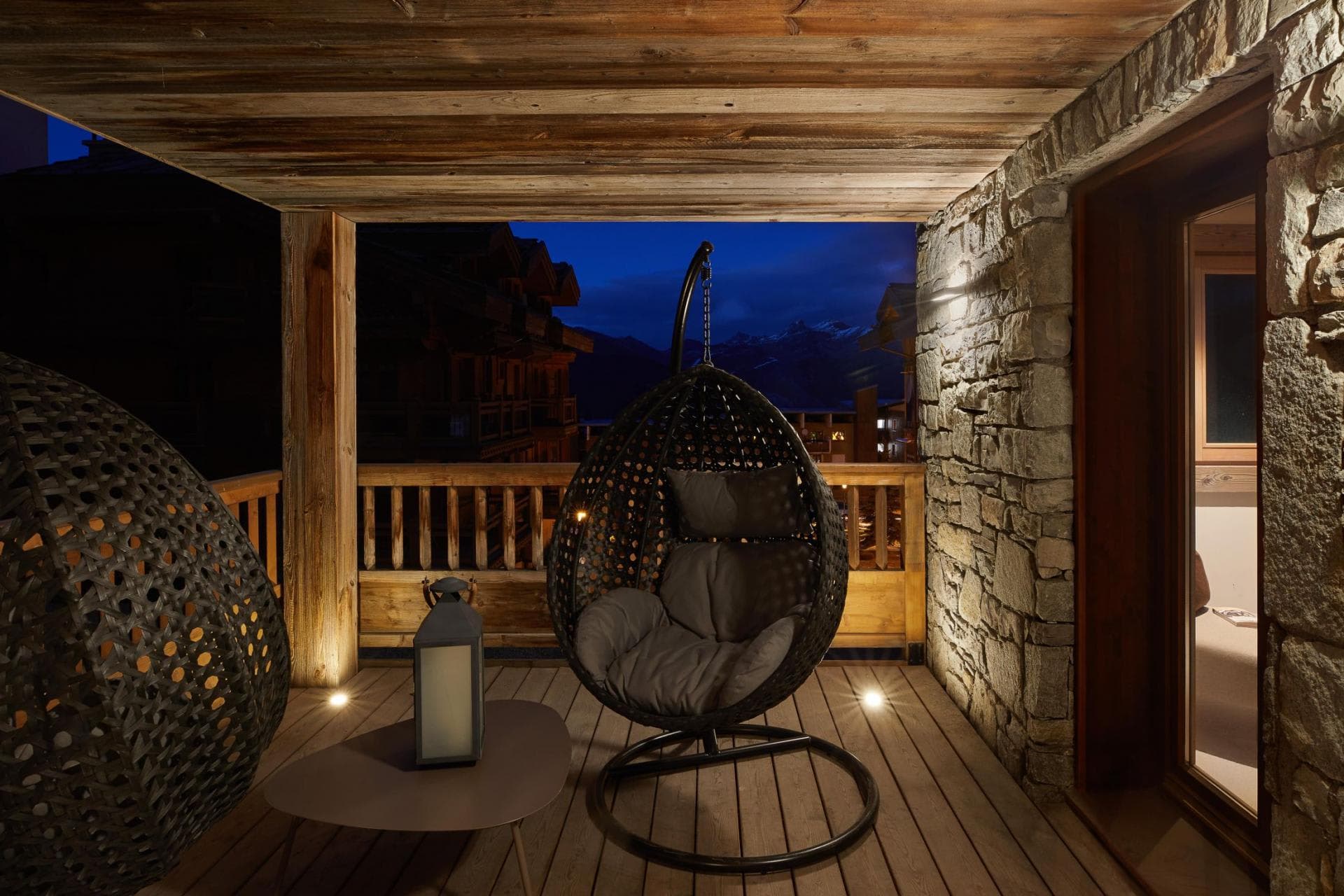 Covered balcony with egg swing chairs and mountain peak views