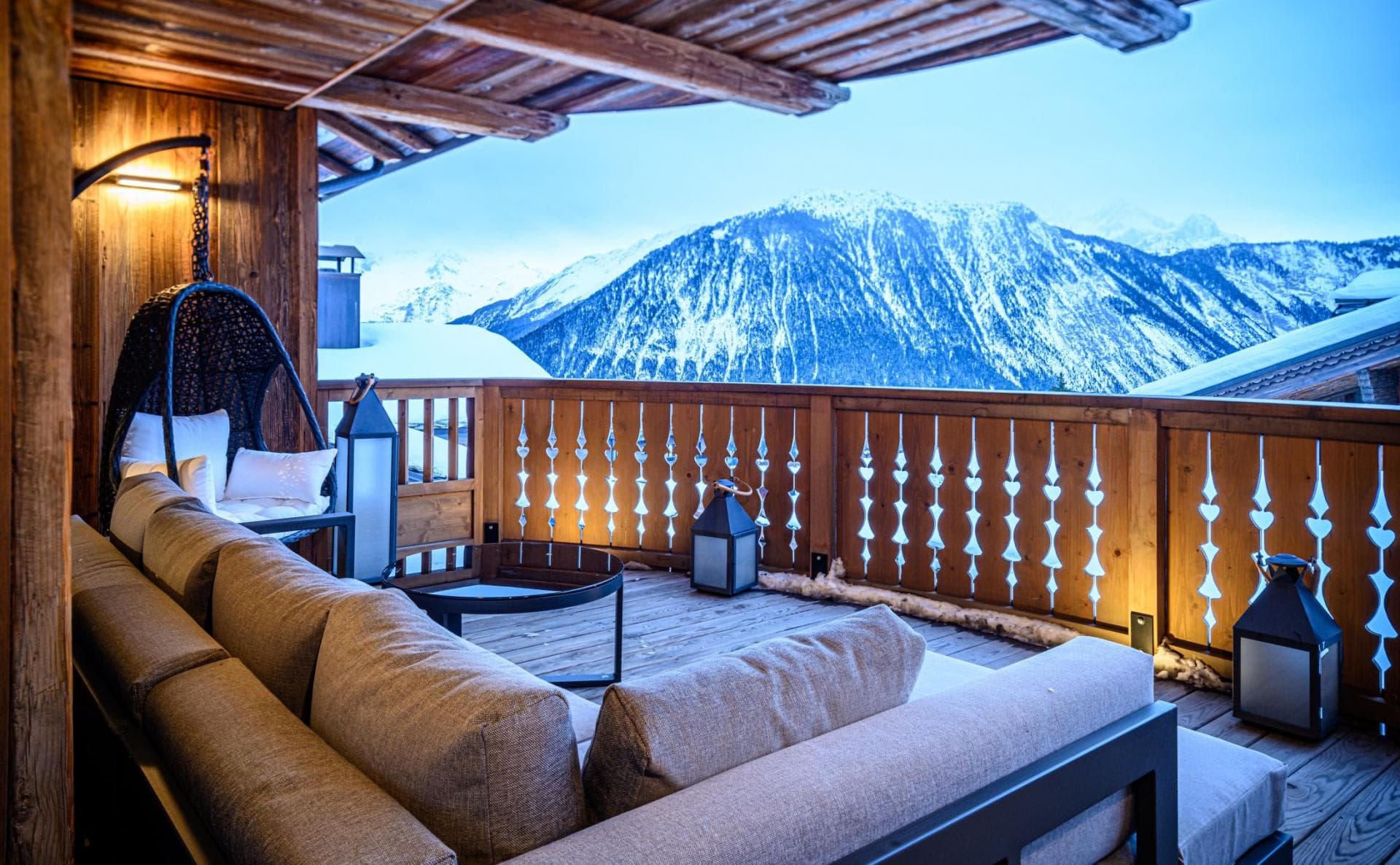 Covered balcony with sectional seating and snow-capped mountain views