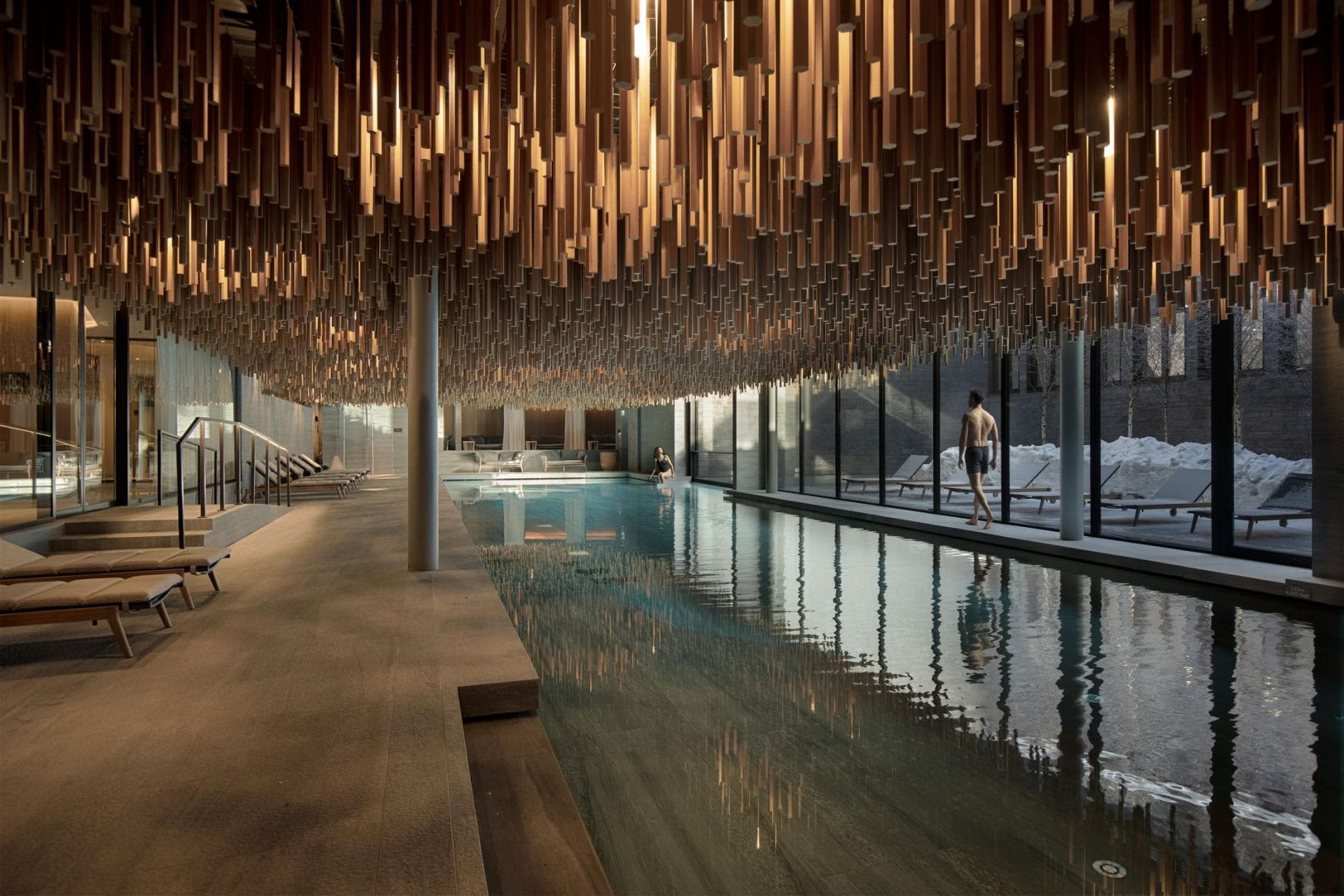 Indoor lap pool with wood-slat ceiling and floor-to-ceiling windows