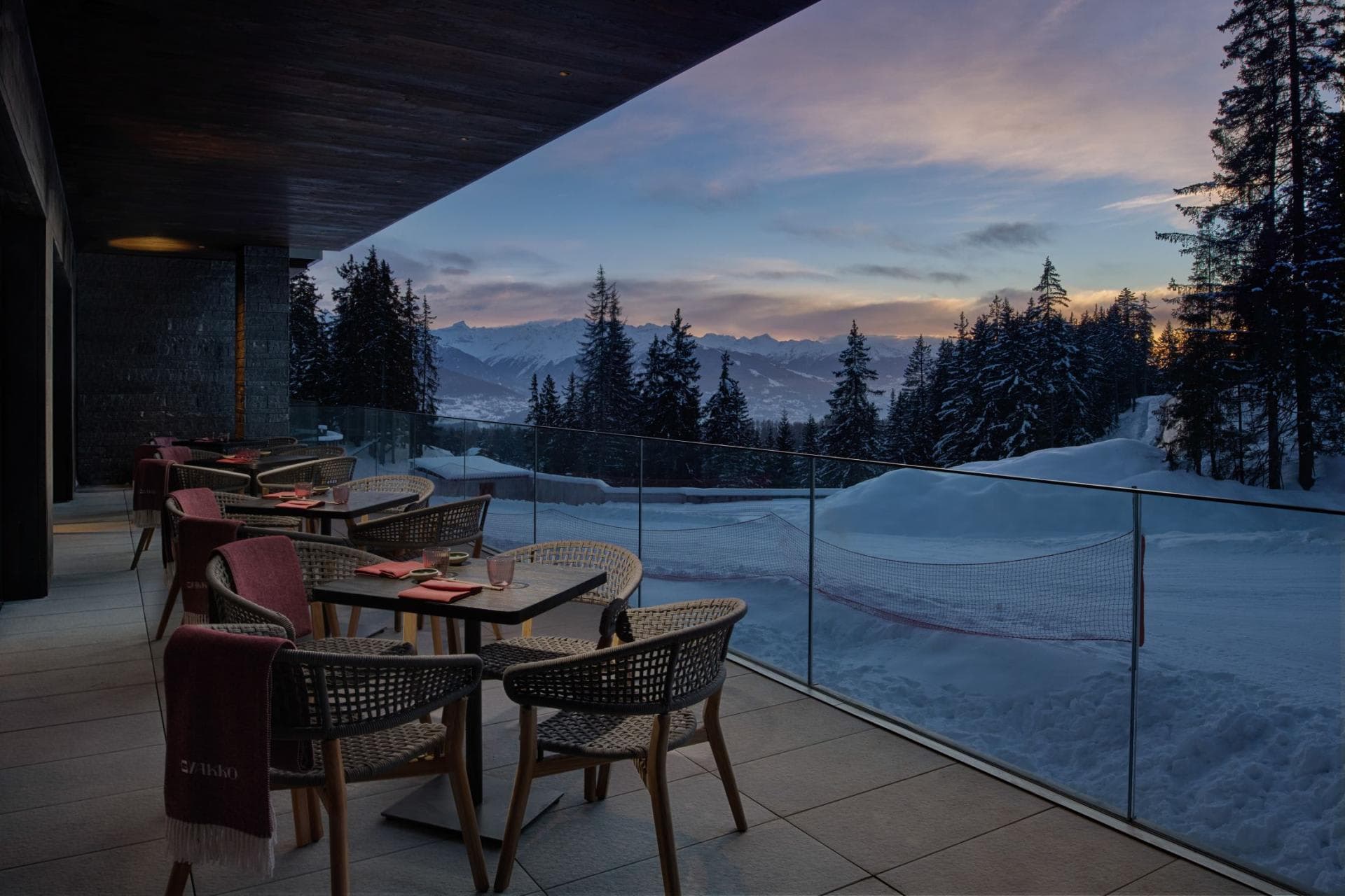 Covered terrace with glass railing and sunset mountain views