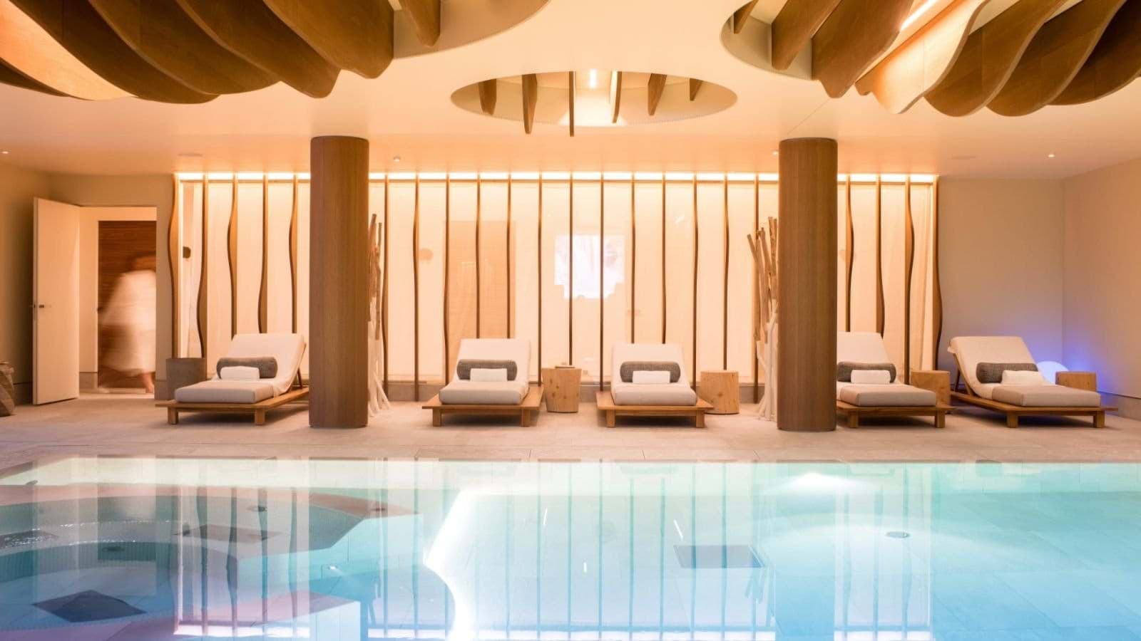 Indoor heated pool with five loungers and integrated hot tub