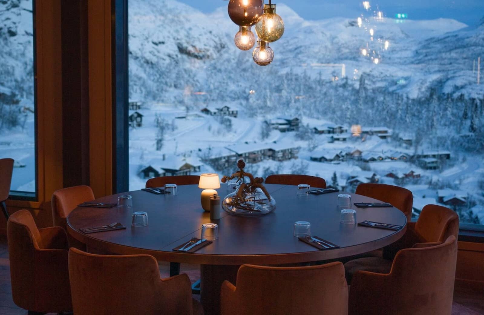 Round dining table seats 8; floor-to-ceiling windows with valley views