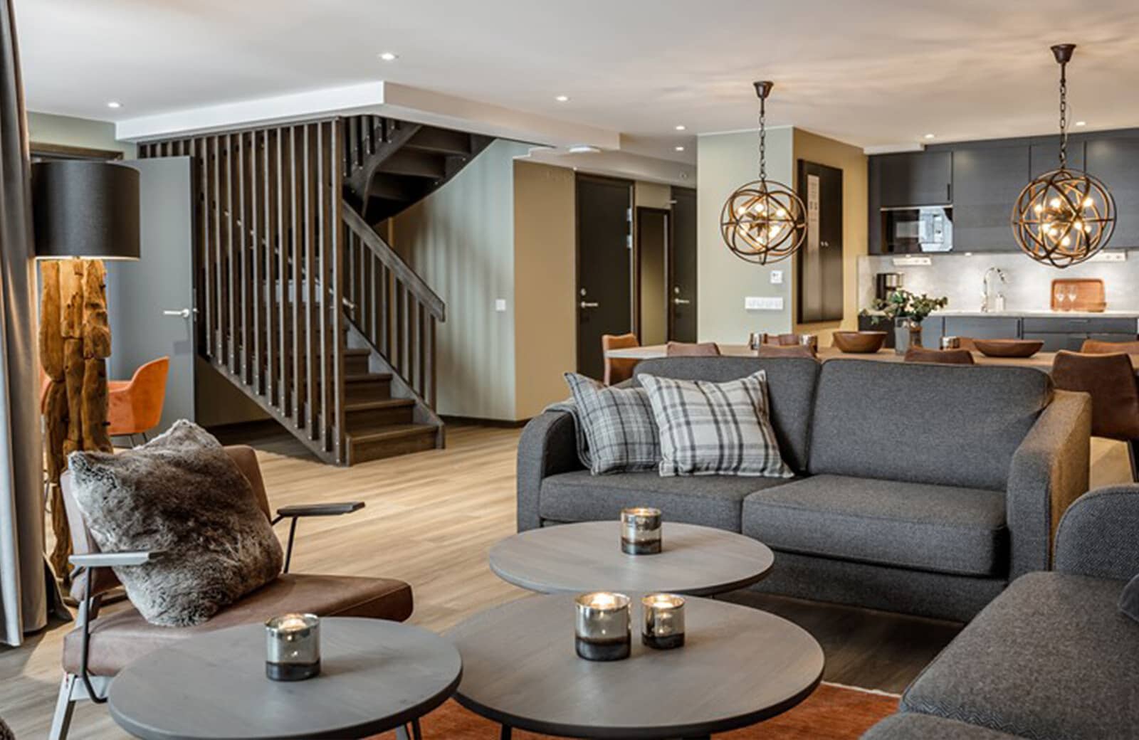 Open-plan living area with slatted wood staircase and kitchen access