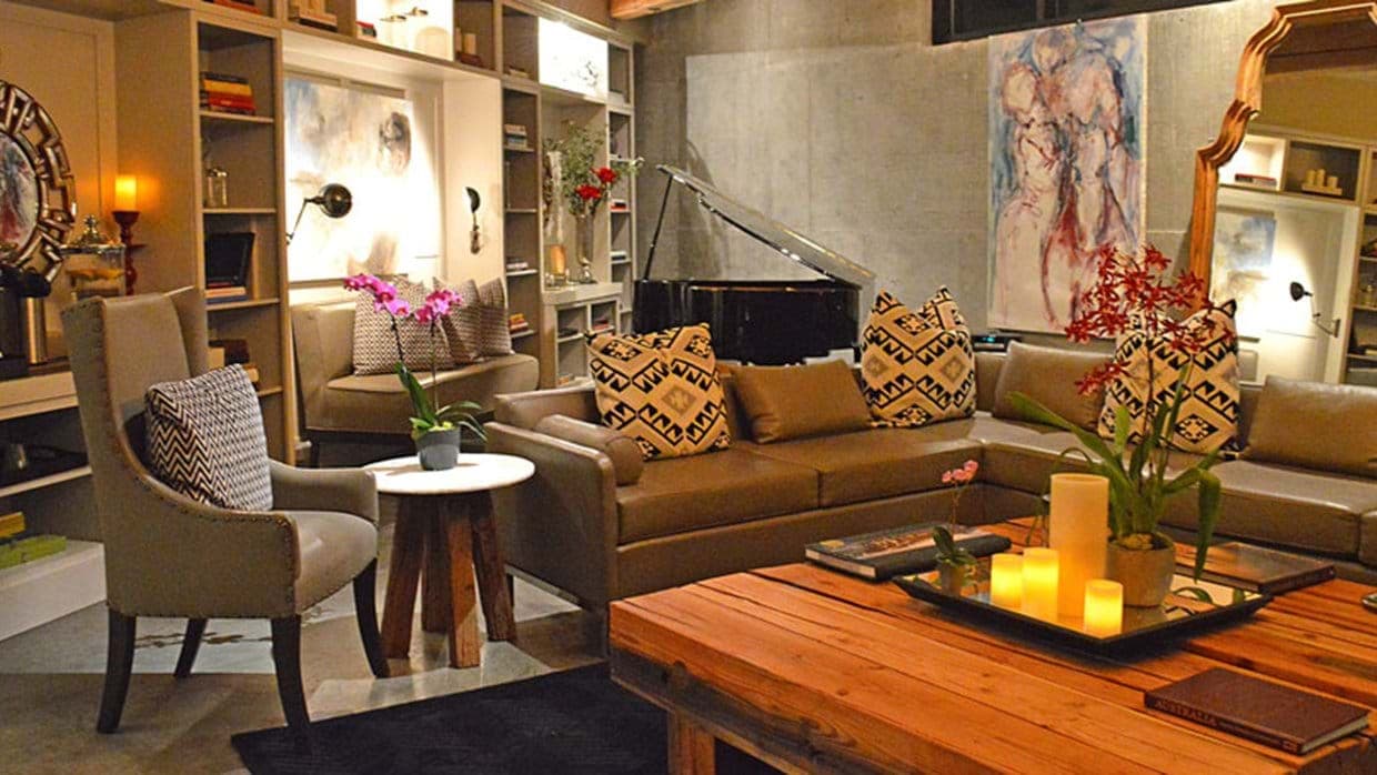 Living area with baby grand piano and built-in library shelving