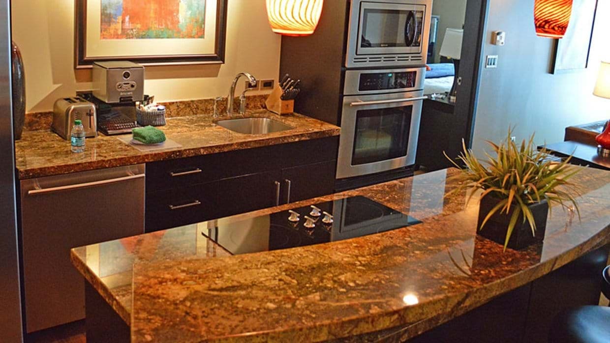 Kitchen with wall oven, espresso machine, and breakfast bar with electric cooktop