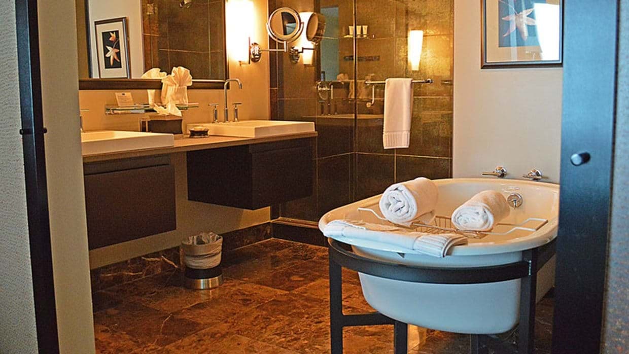 Bathroom with dual vanity, soaking tub, and walk-in glass shower