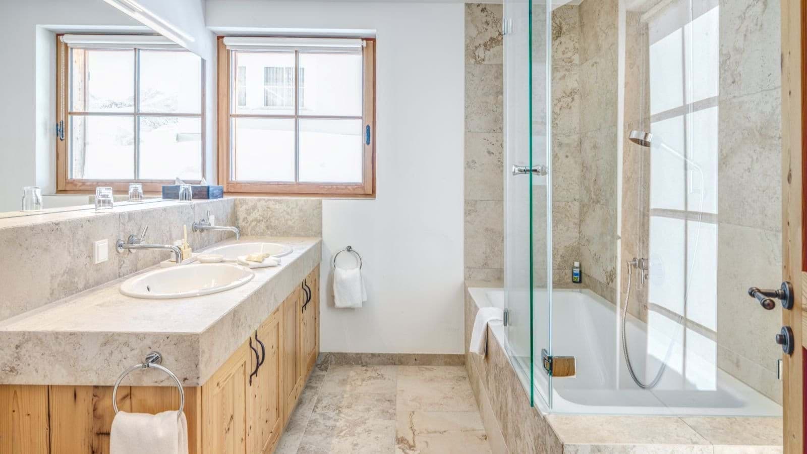 Bathroom with dual vanity and soaking tub with glass partition