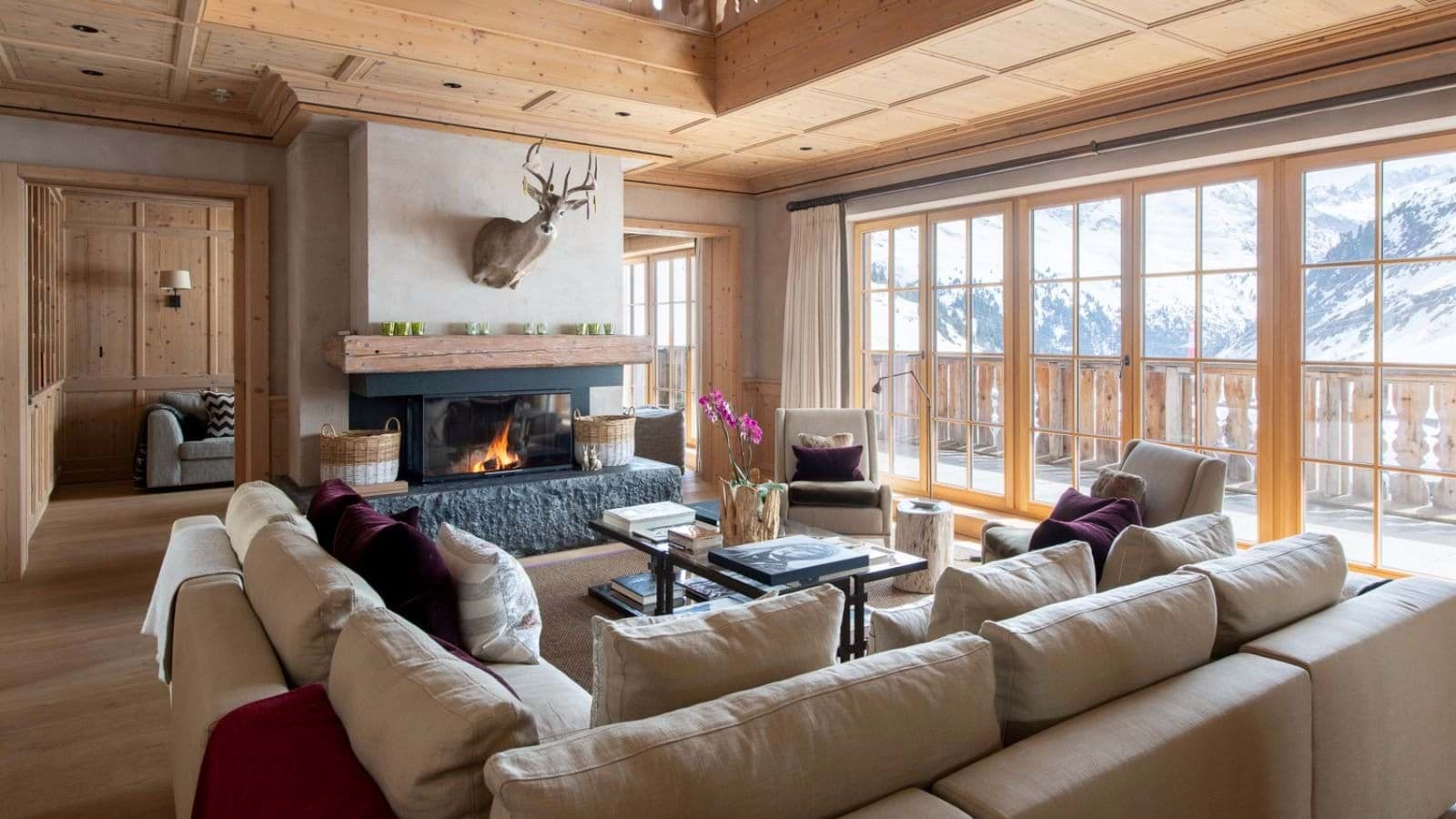 Living area with wood-burning fireplace and floor-to-ceiling mountain views