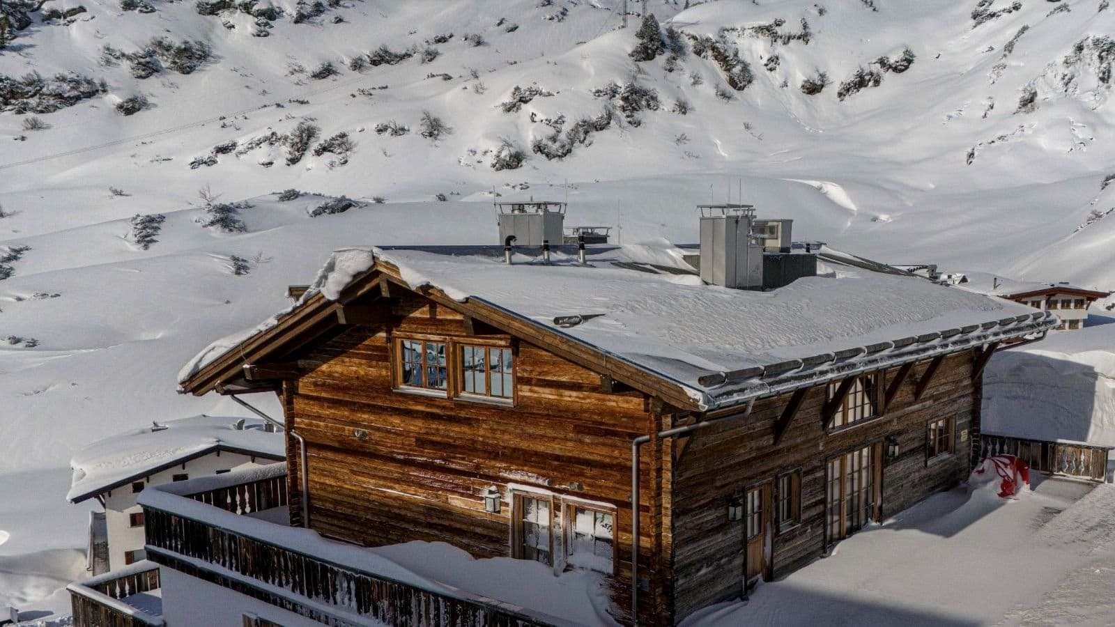 Ski-in, ski-out timber chalet with snow-covered mountain backdrop