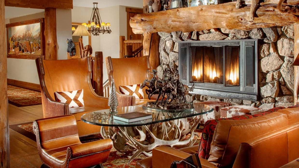 Stone fireplace lounge with leather seating and antler coffee table