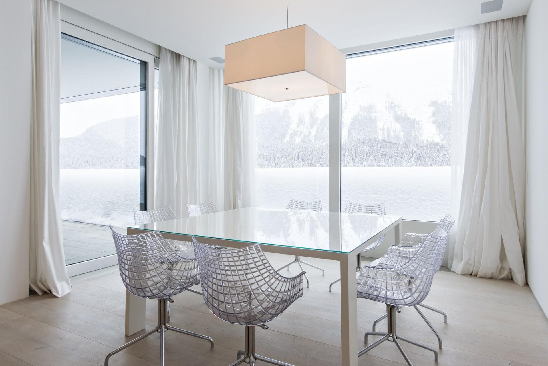 Dining table seats 8; floor-to-ceiling snowy mountain views