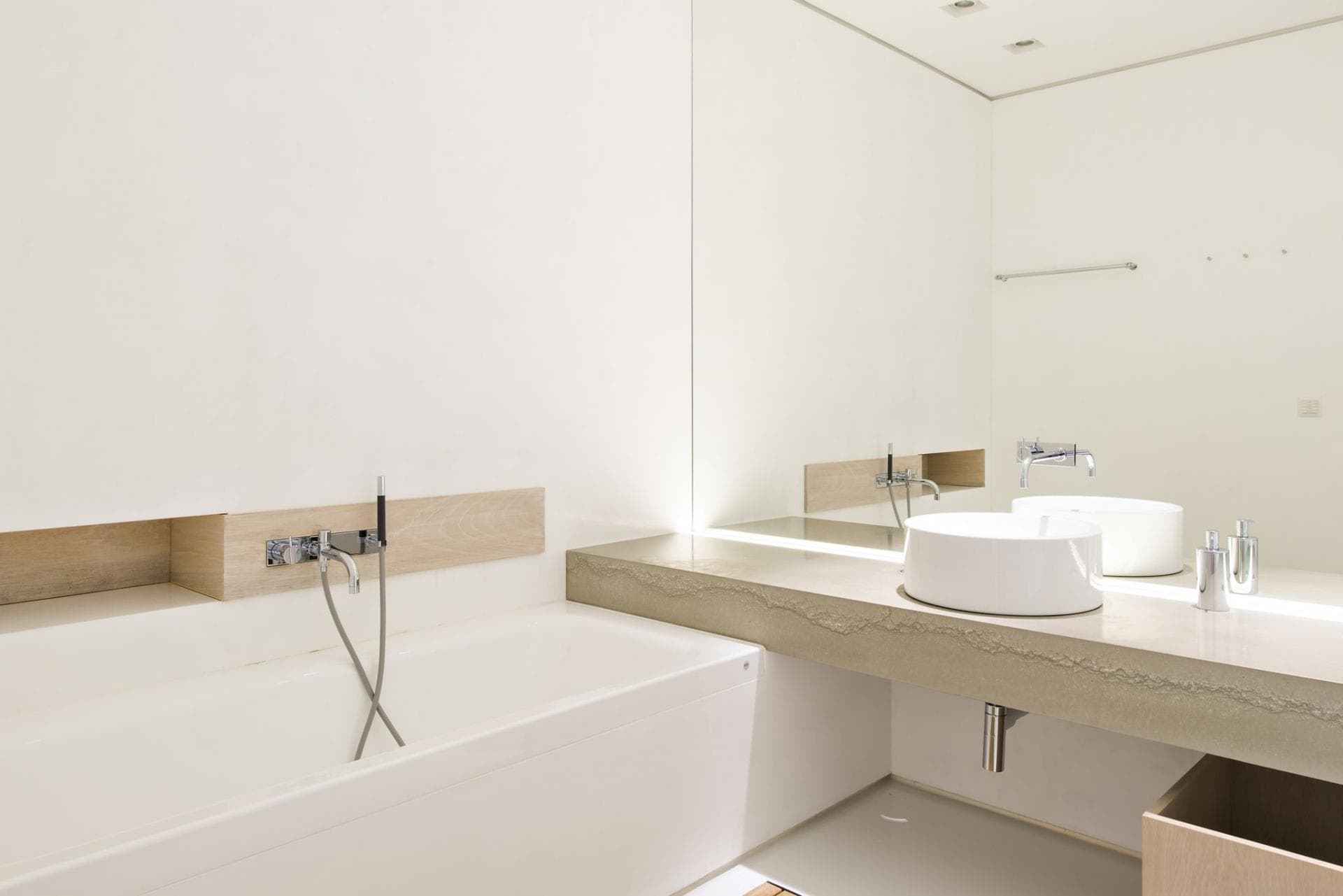 Bathroom with soaking tub and vessel sink on textured stone vanity