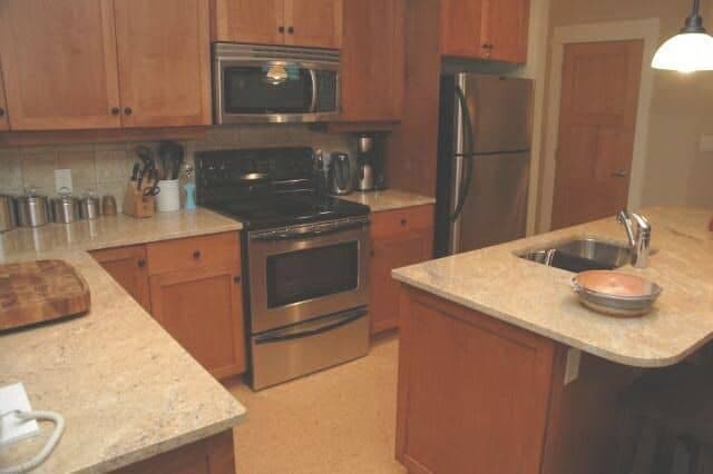 Kitchen with stainless steel appliances and island with prep sink