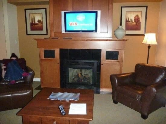 Living area with gas fireplace and wall-mounted TV above mantle