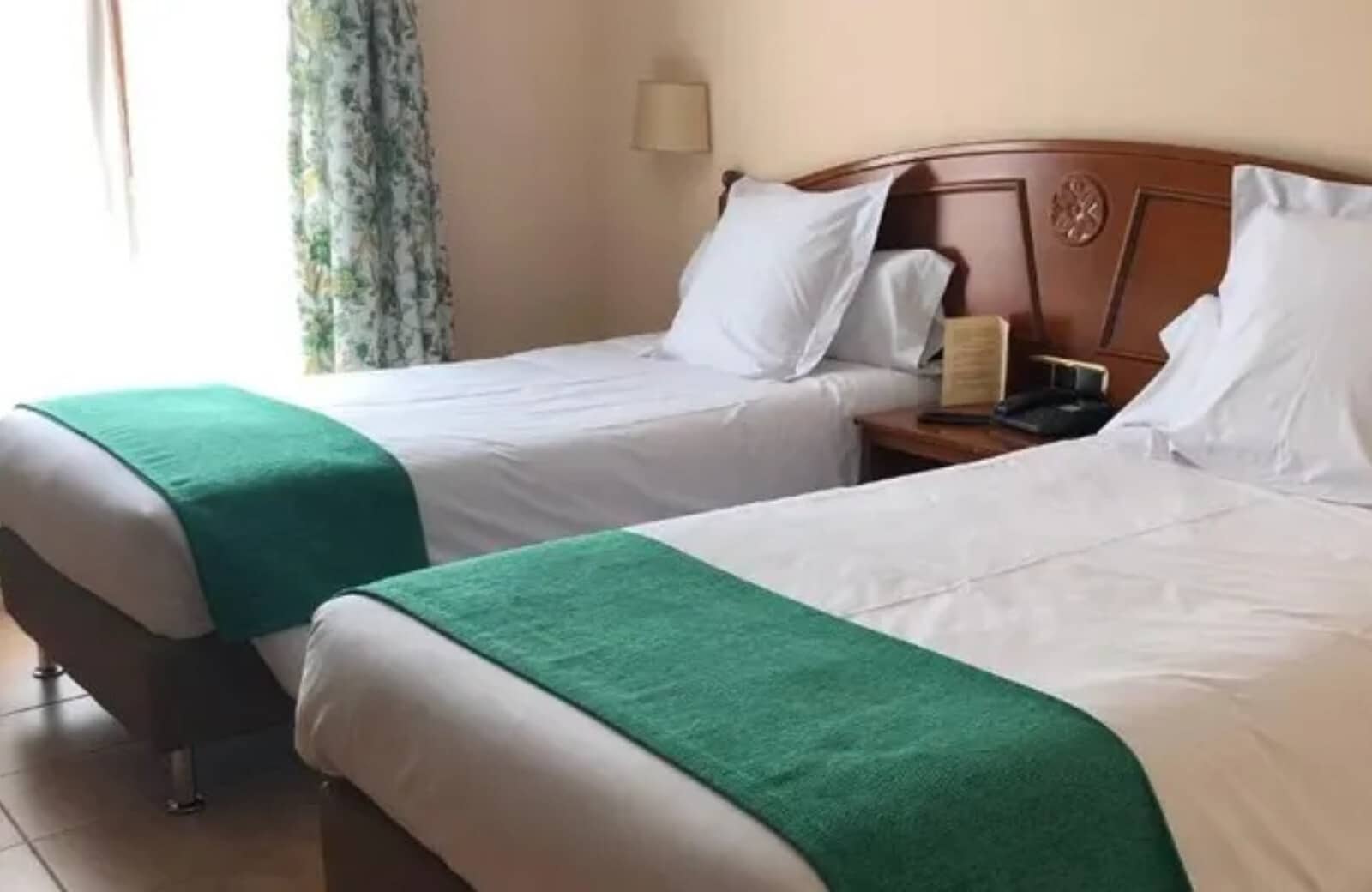 Bedroom with two twin beds and carved wood headboard