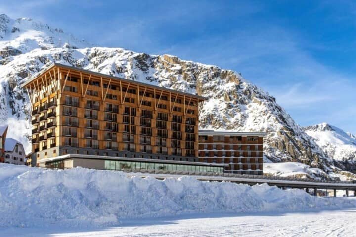 Ski-in/ski-out lodge exterior with private balconies and mountain backdrop