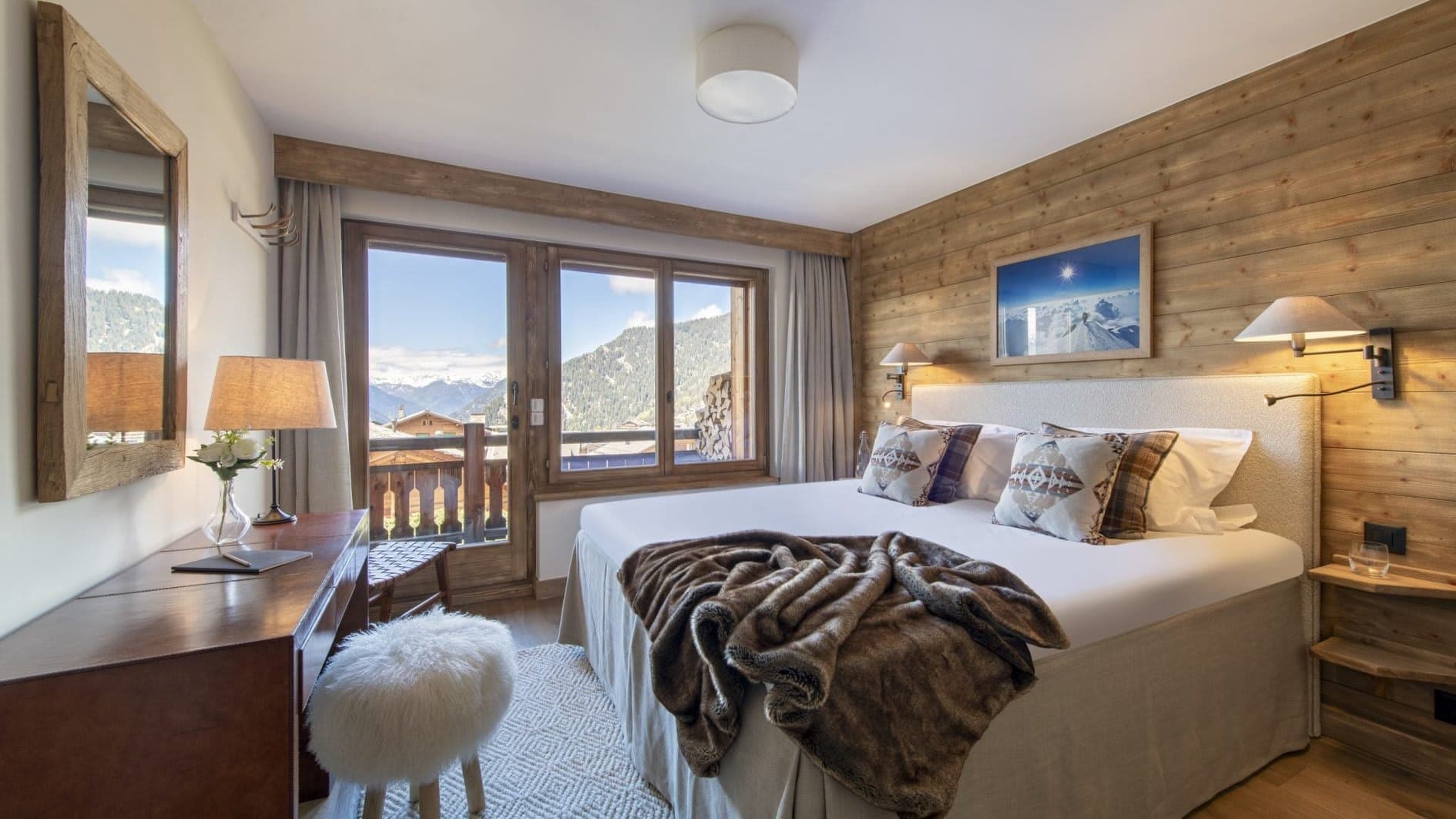 Primary bedroom with king bed, writing desk, and private balcony access