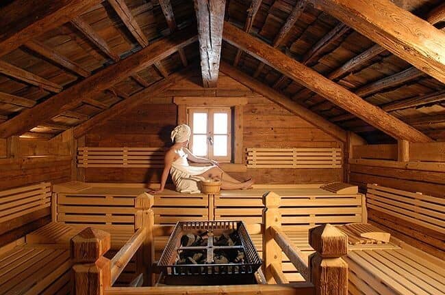Log cabin sauna with multi-level bench seating and window