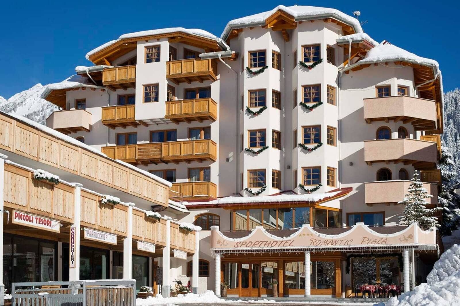 Hotel exterior with private wooden balconies and village shop access