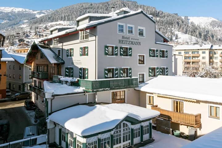 Hotel Heitzmann exterior with traditional shutters and nearby mountain ski slopes
