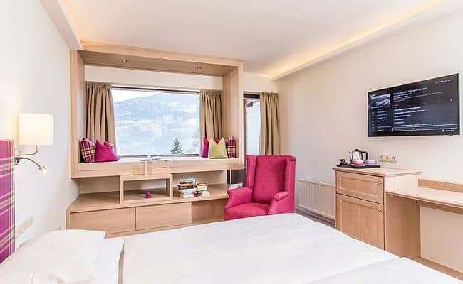 Guest bedroom with built-in window seat and alpine mountain views