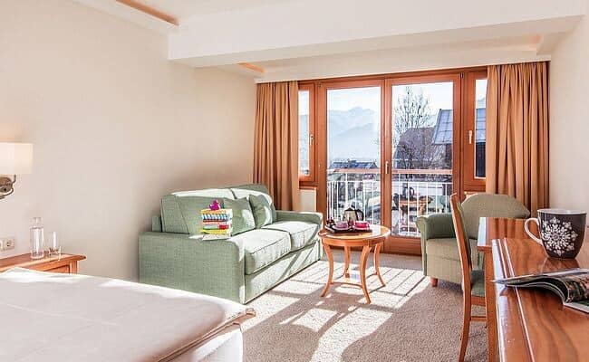 Guest suite with sofa seating and private balcony access