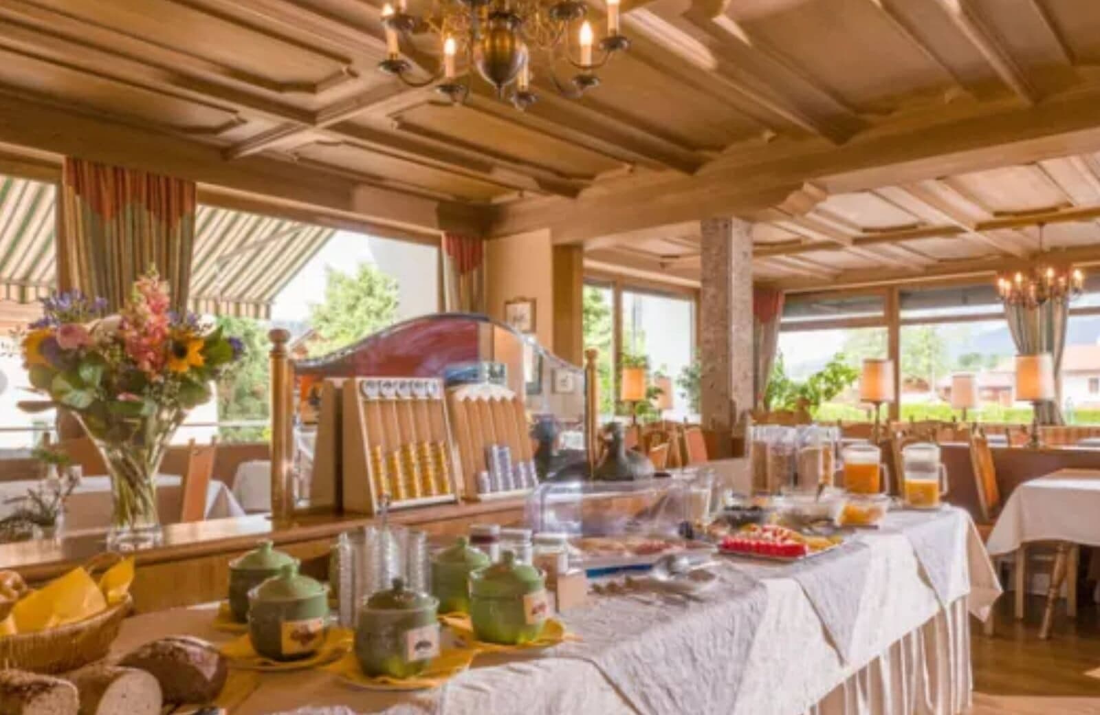 Breakfast buffet area with wood coffered ceilings and table seating