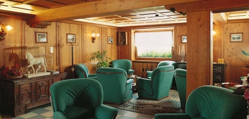 Lounge with traditional wood paneling and armchair seating for 7