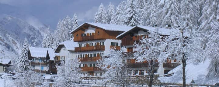 Alpine building exterior featuring private balconies and snowy mountain setting