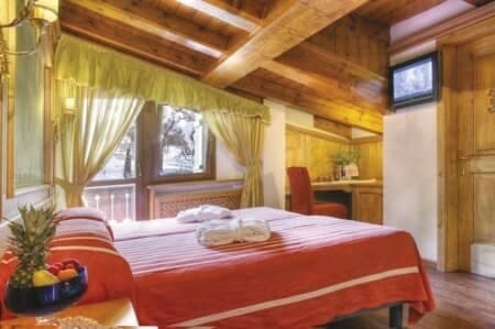 Bedroom with vaulted wood ceilings, king bed, and dedicated workspace