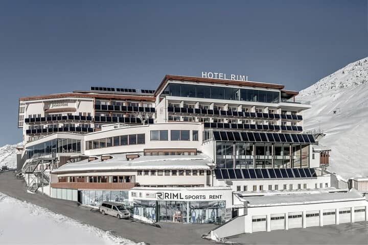 Ski-in/ski-out hotel exterior with on-site sports rental shop and solar panel array