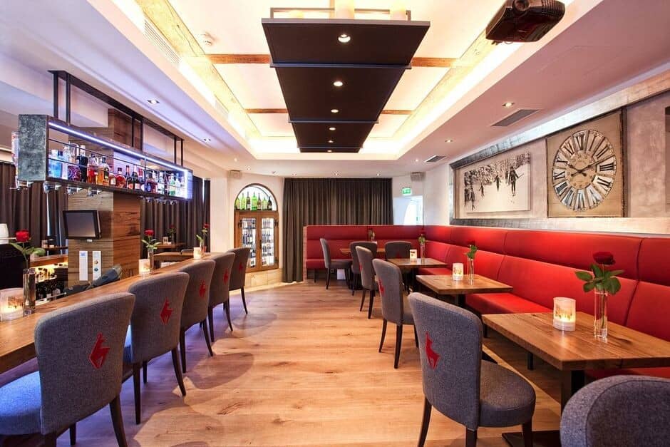 Bar and lounge with red banquette seating and ceiling-mounted projector