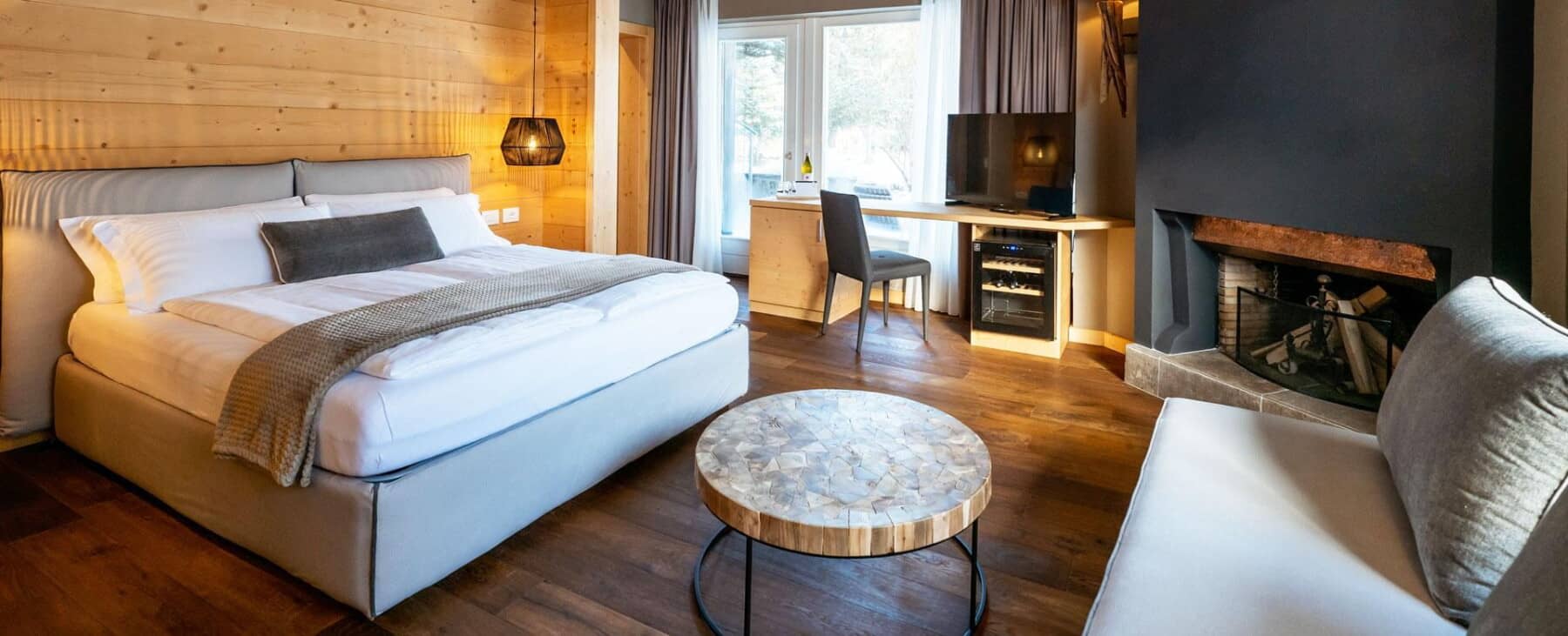 Primary bedroom with king bed, wood-burning fireplace, and wine fridge