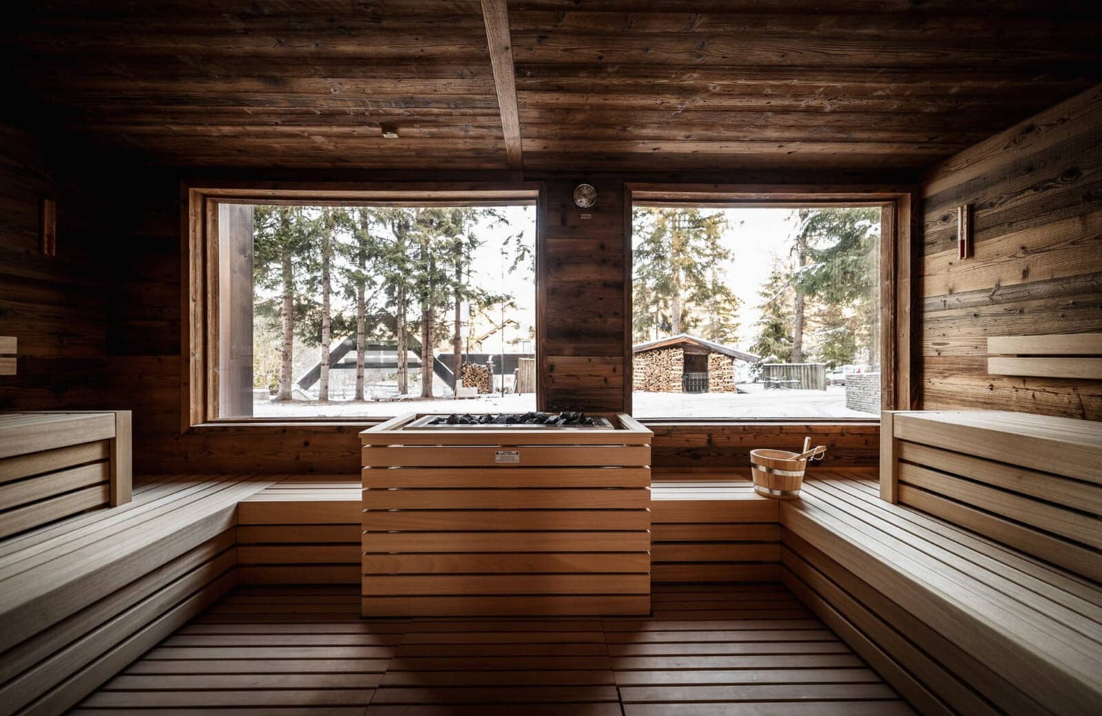 Wood-paneled sauna with forest views and multi-level bench seating