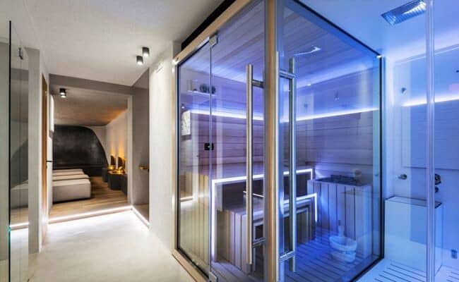 Private glass-walled sauna with integrated LED lighting and tiered bench seating