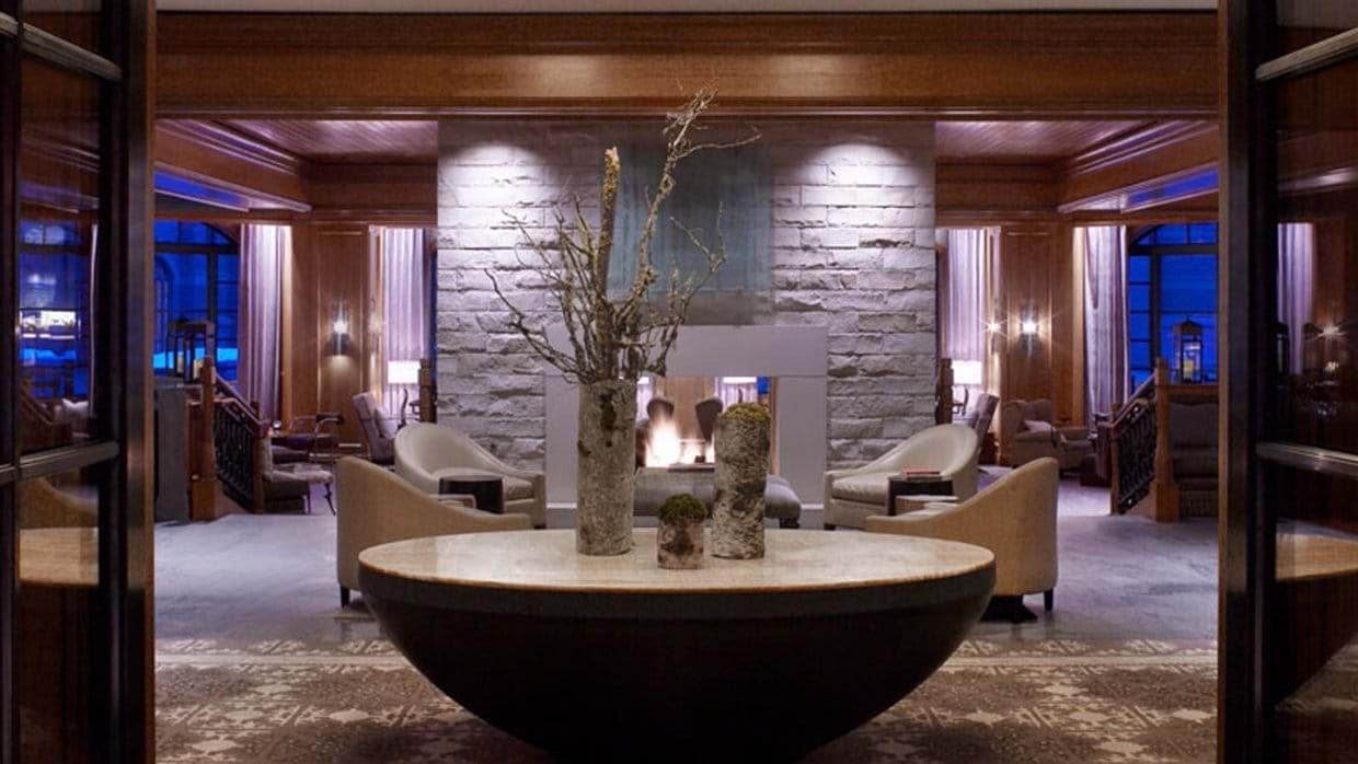 Lobby lounge with double-sided stone fireplace and wood paneling