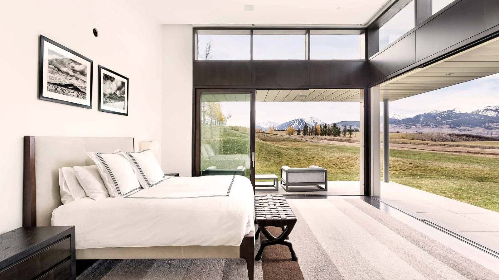 Primary bedroom with king bed and floor-to-ceiling mountain views