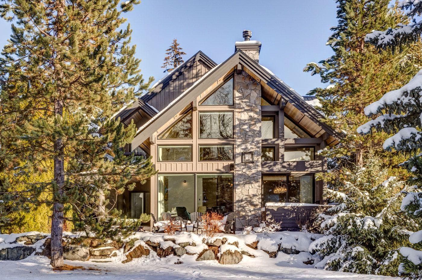 A-frame exterior with floor-to-ceiling windows and stone chimney