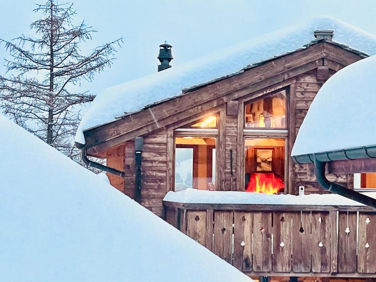 Timber chalet exterior featuring wood-burning fireplace and private balcony