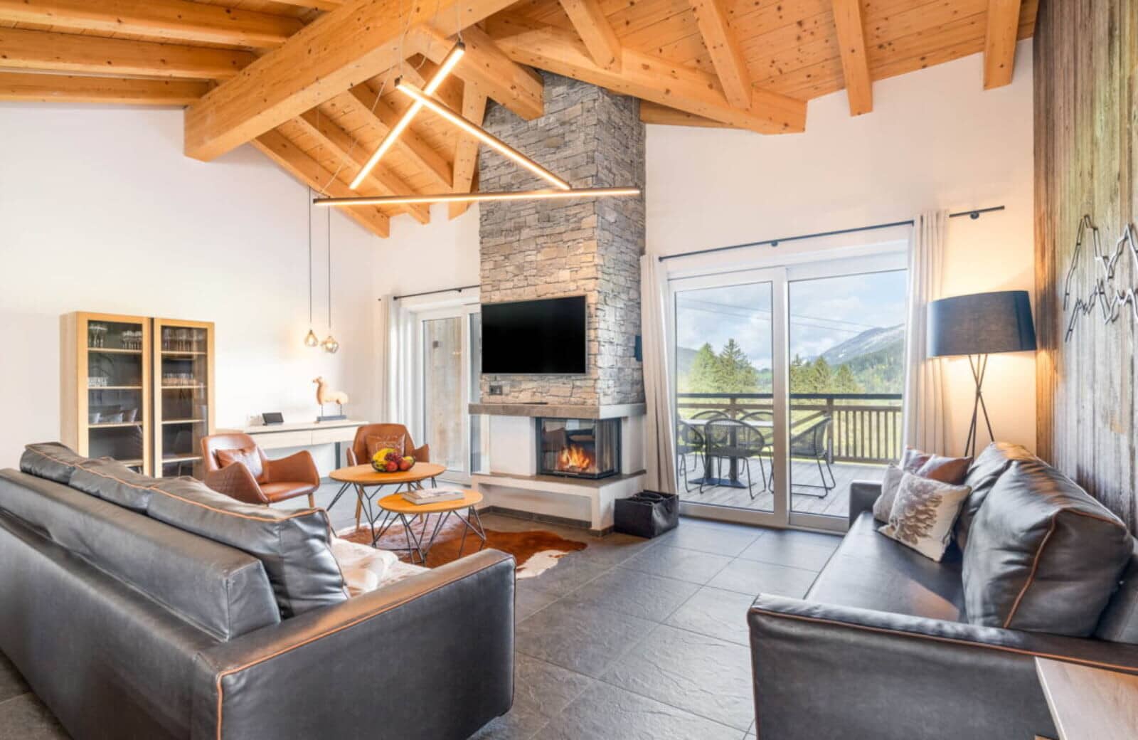 Living area with wood-burning fireplace and balcony access to mountain views