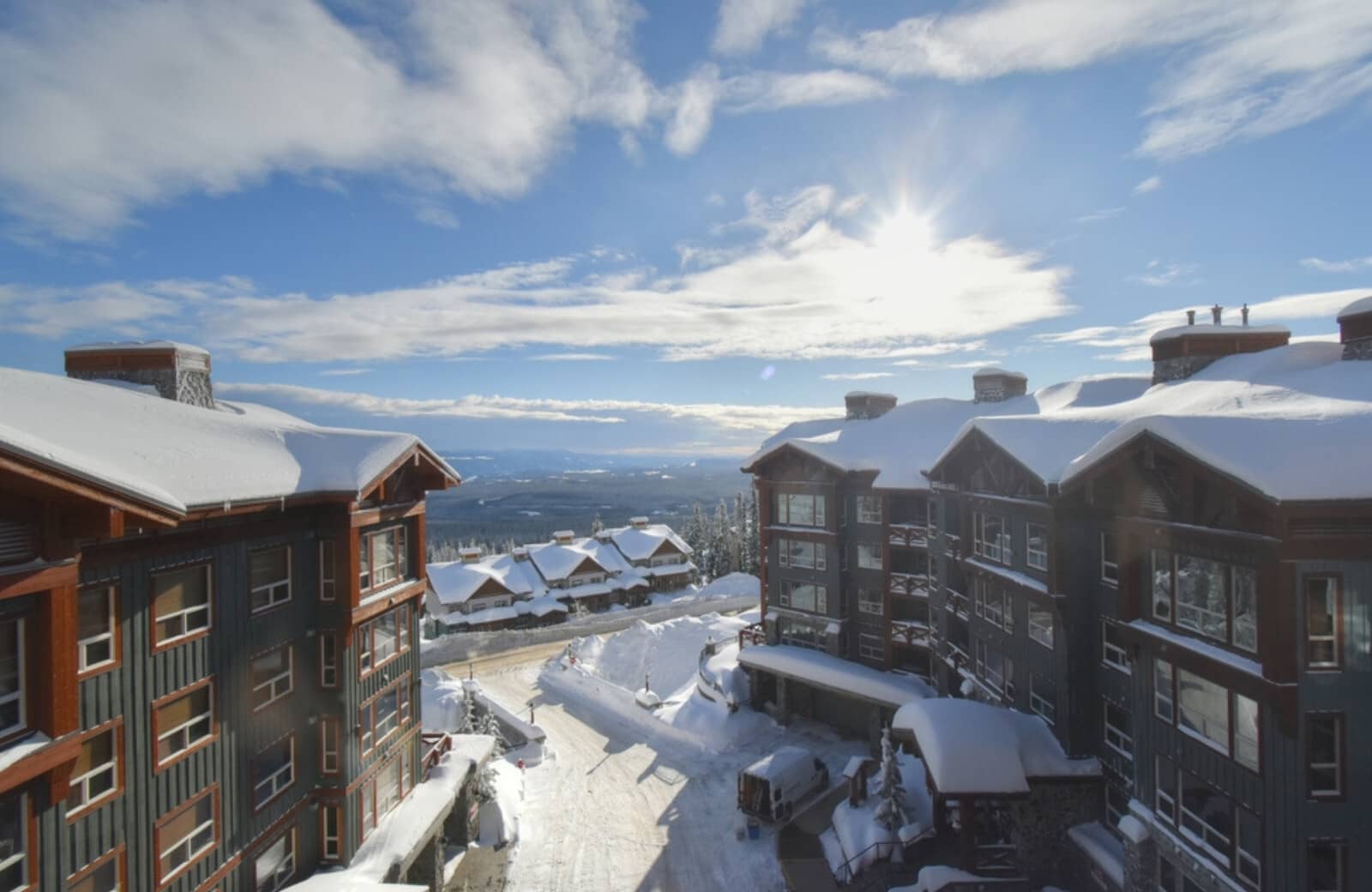 Ski resort view from balcony overlooking snow-covered village and valley