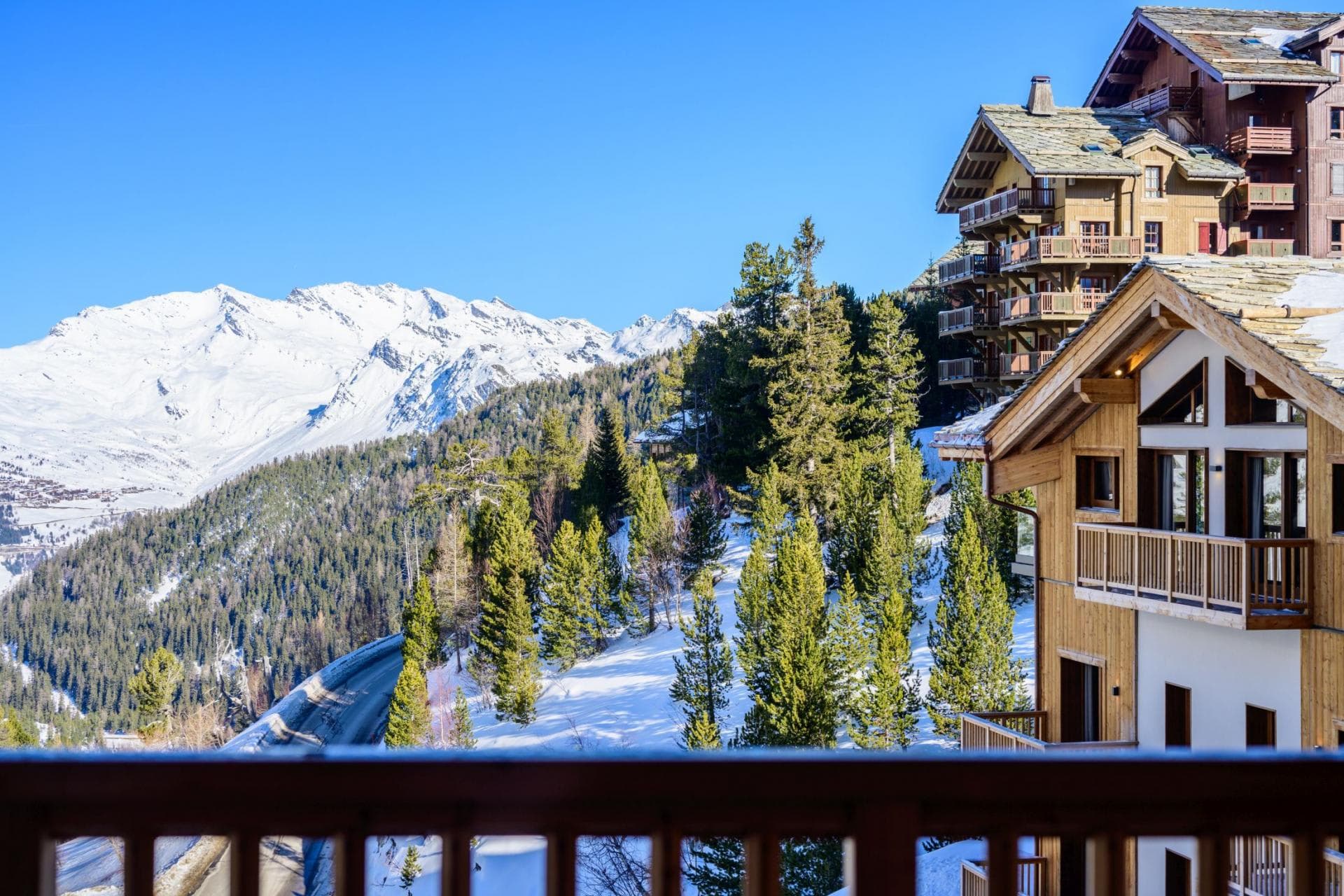 Private balcony view of snow-capped mountains and alpine forest