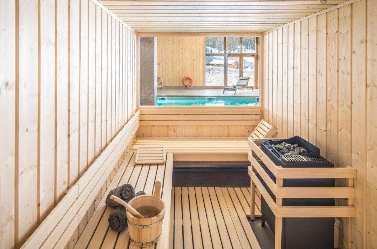 Sauna with tiered seating and large window overlooking pool area